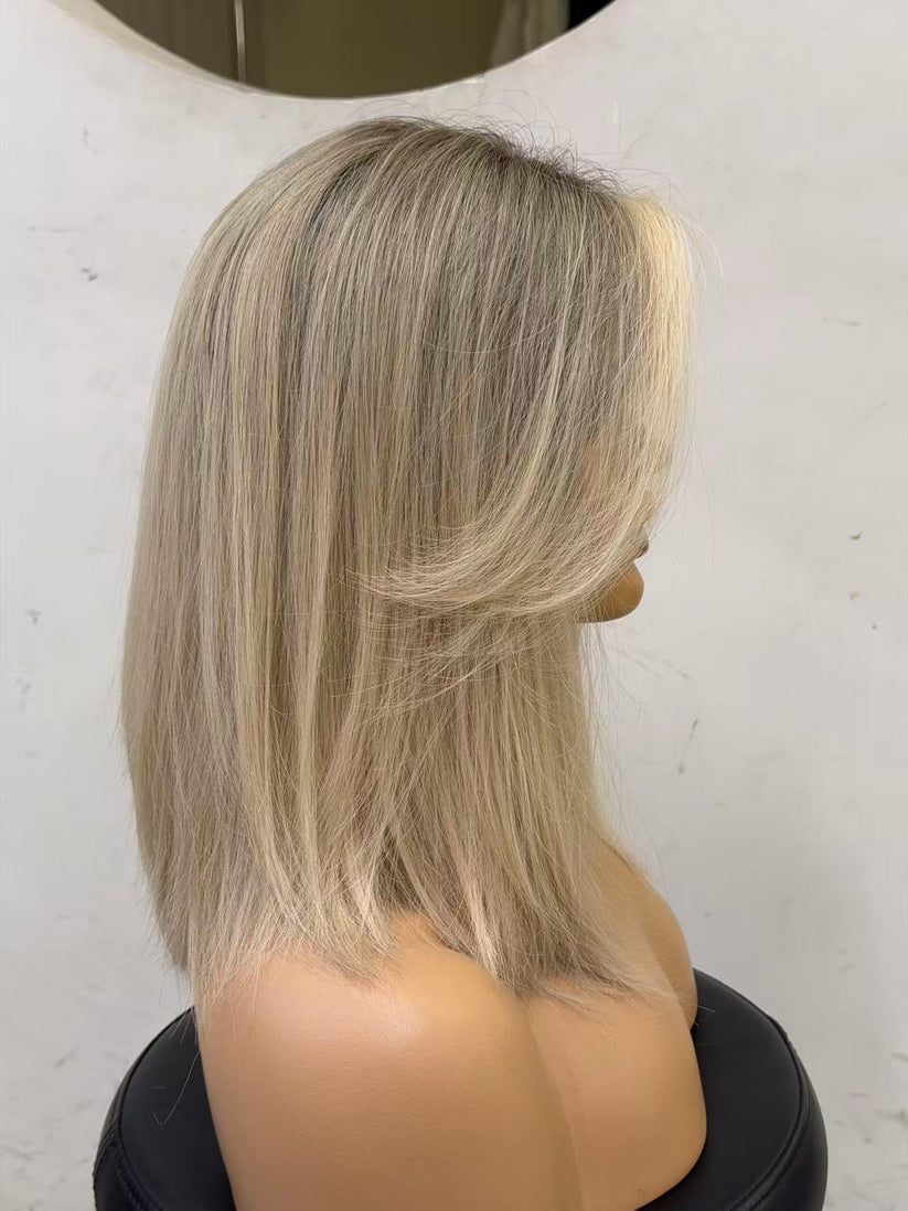 Mannequin head with blonde hair styled in a bob against a white background