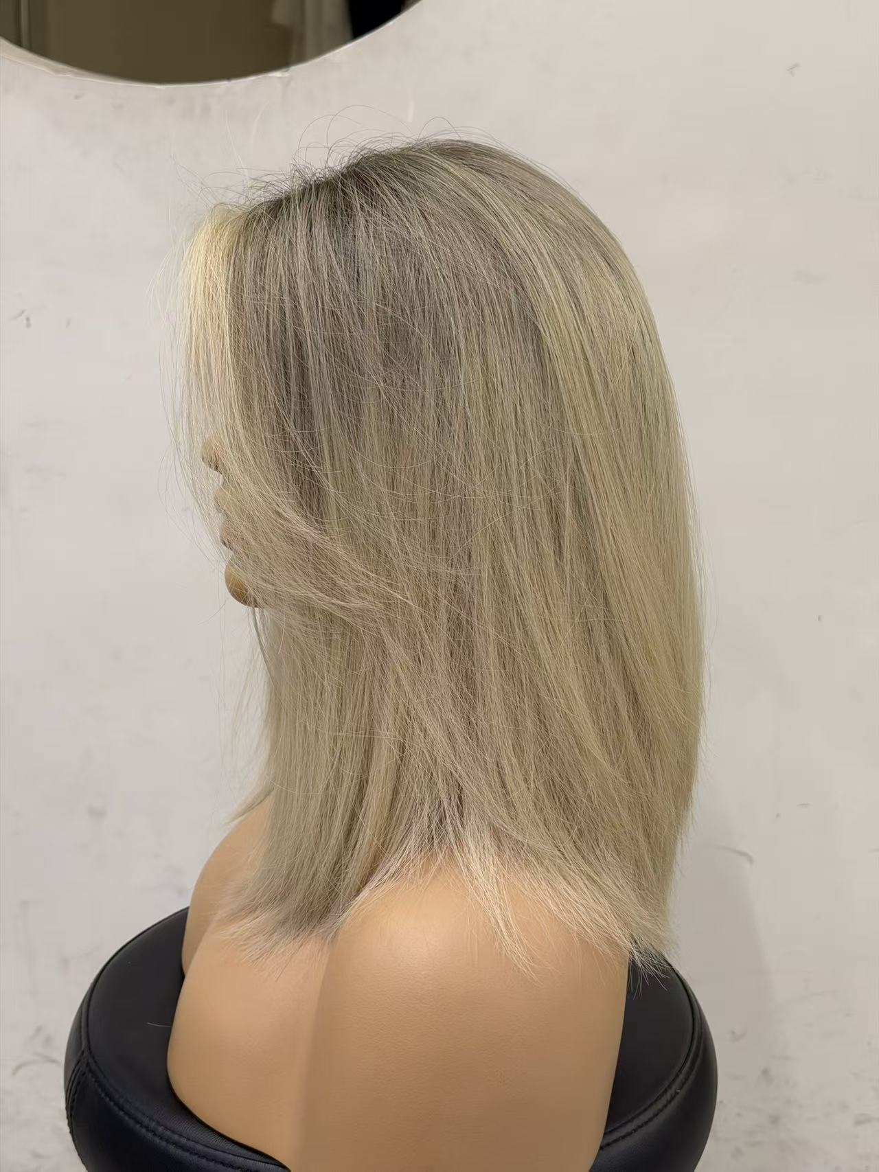 Blonde wig on a mannequin head against a white background